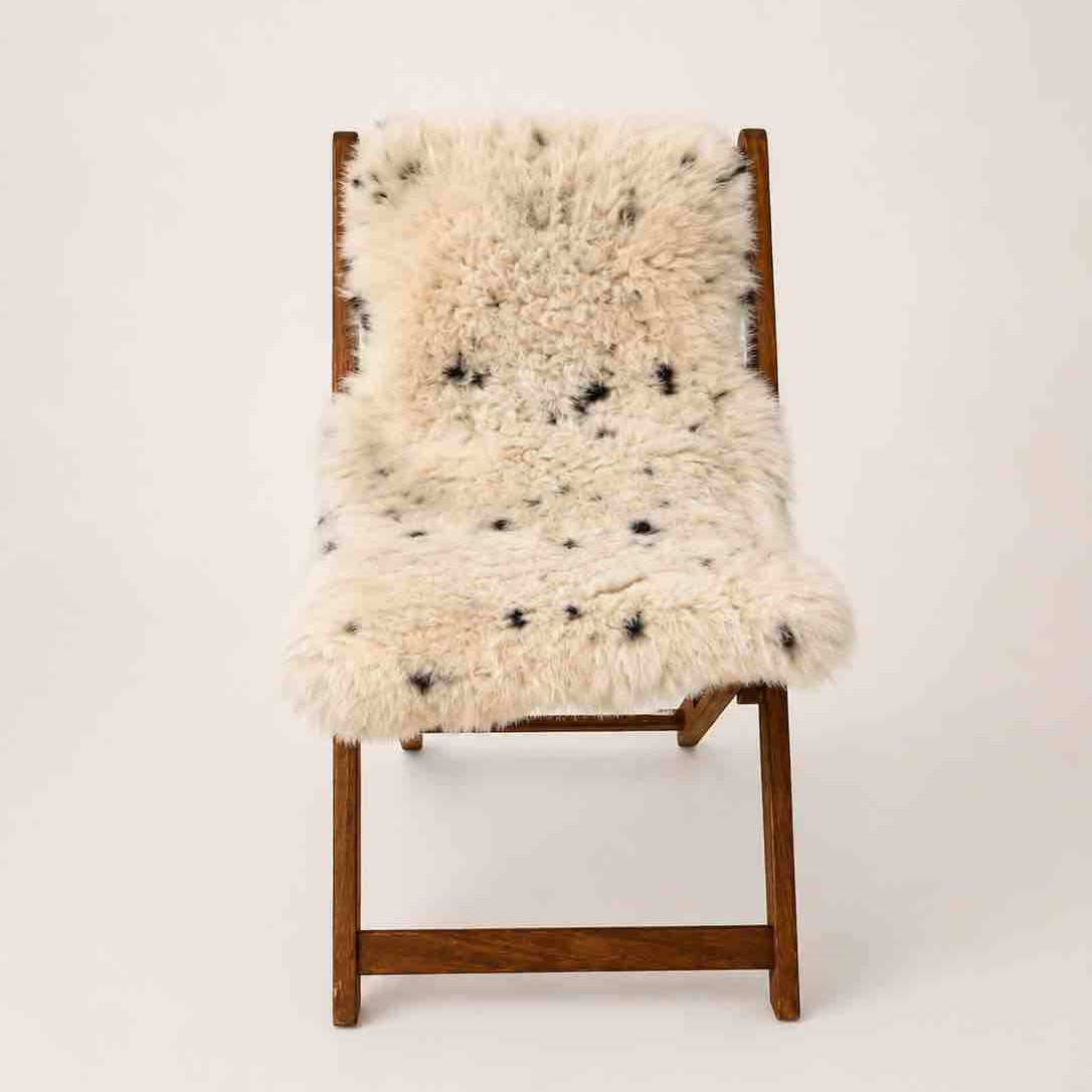 Wooden chair with a sheepskin cover on a white background