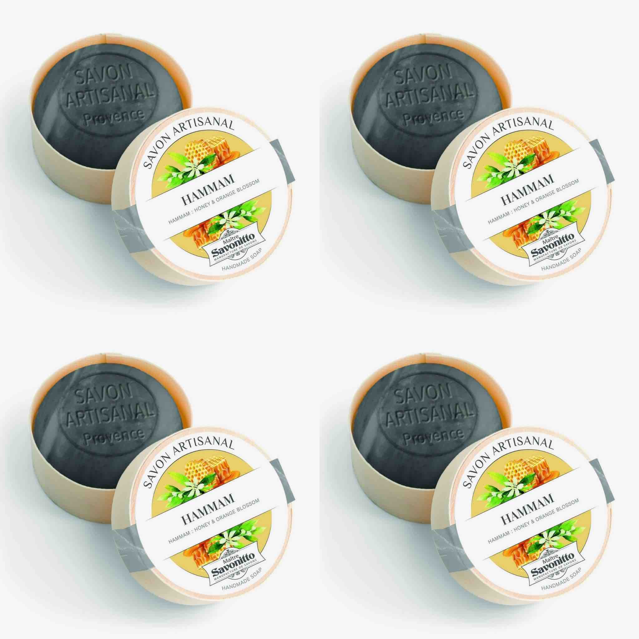 Set of four artisanal soaps with labels on a white background