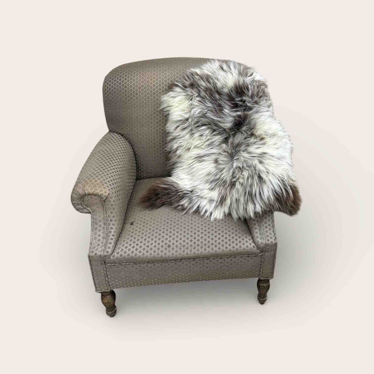 Gray armchair with a fur throw on a white background
