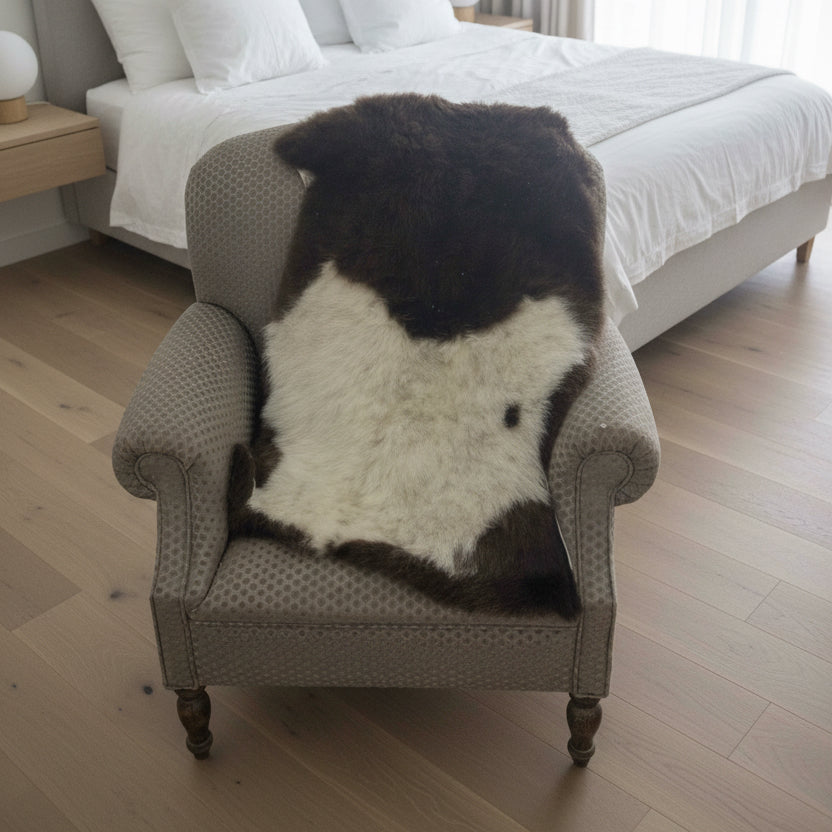Gray armchair with a brown and white fur throw in a room setting.