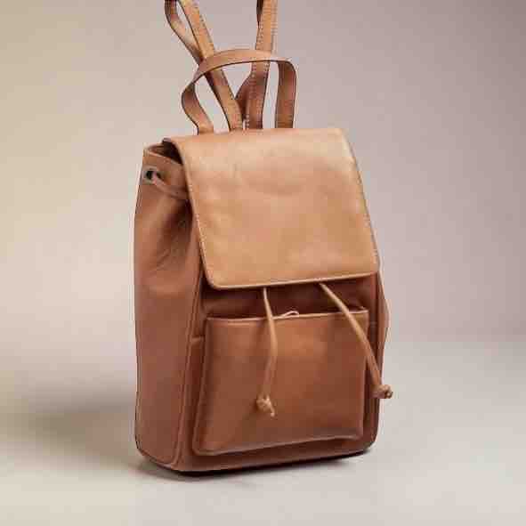 Brown leather backpack on a light gray background