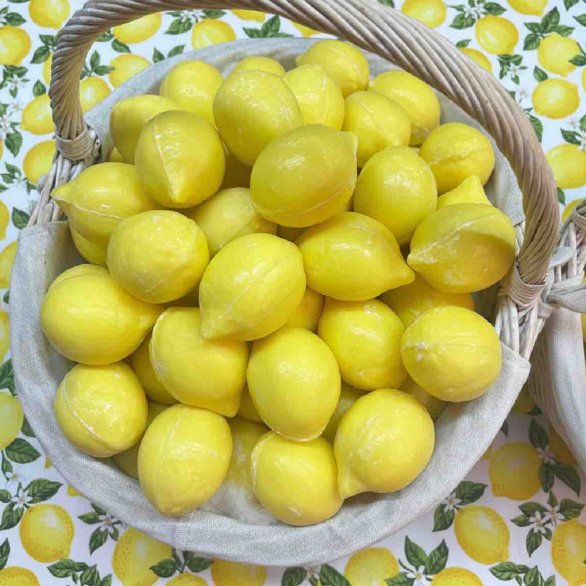 Basket of lemons on a patterned background with lemons and leaves.