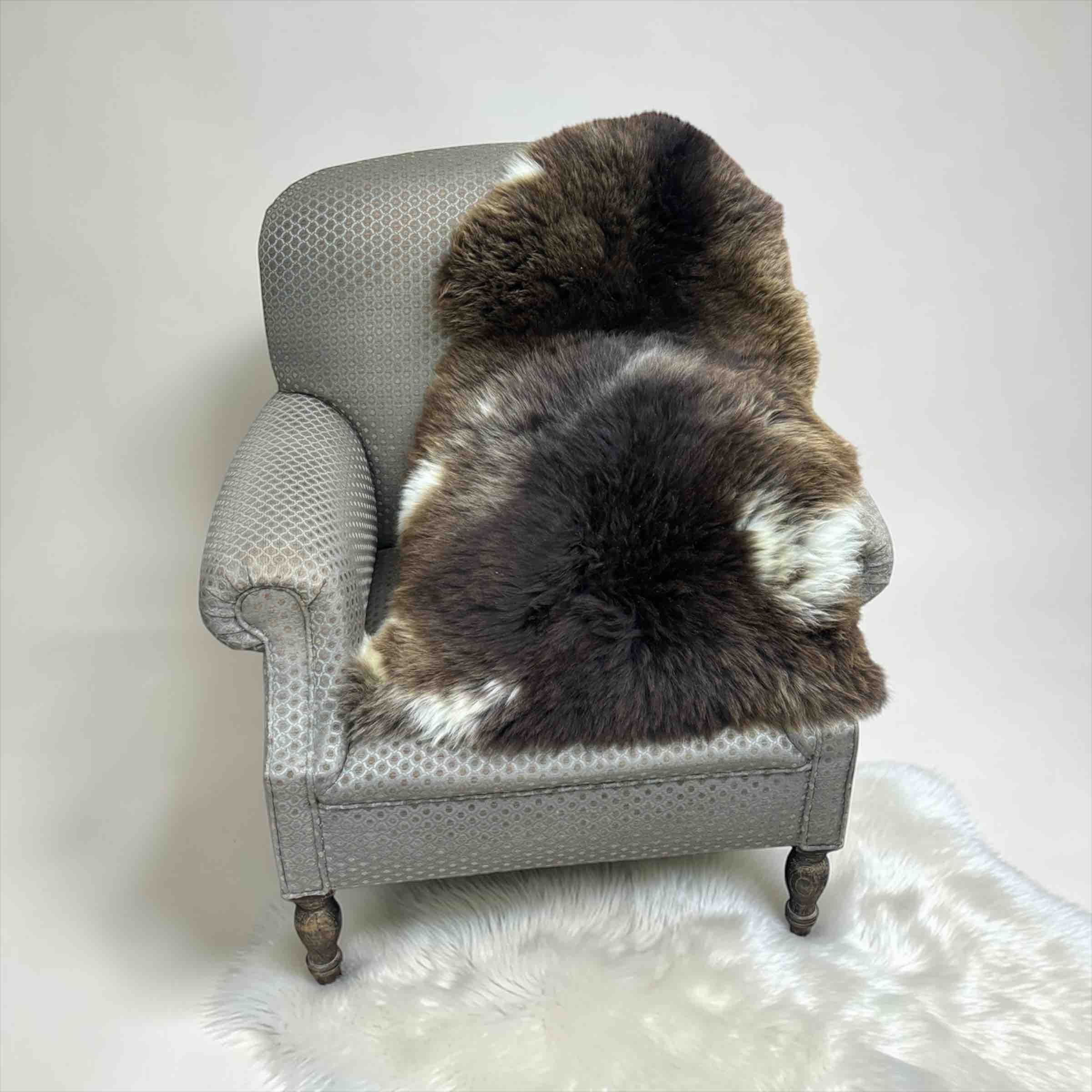 Gray armchair with a brown fur throw on a white background