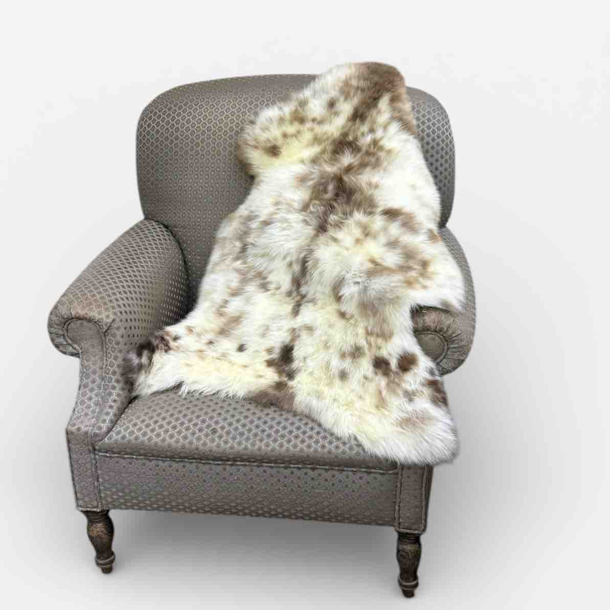 Gray armchair with a fur throw on a white background