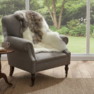 Brown and white fur throw draped over a patterned armchair on a light gray background