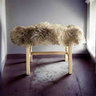 Bench with fluffy beige cushion on a plain background