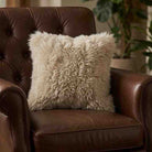Brown leather armchair with a fluffy beige pillow in a home setting