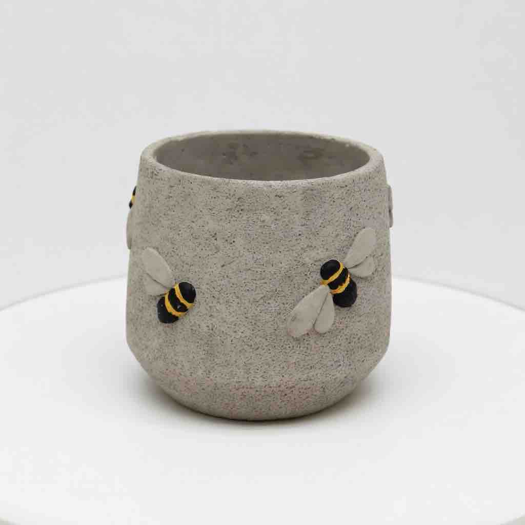 Concrete cup with bee designs on a white background
