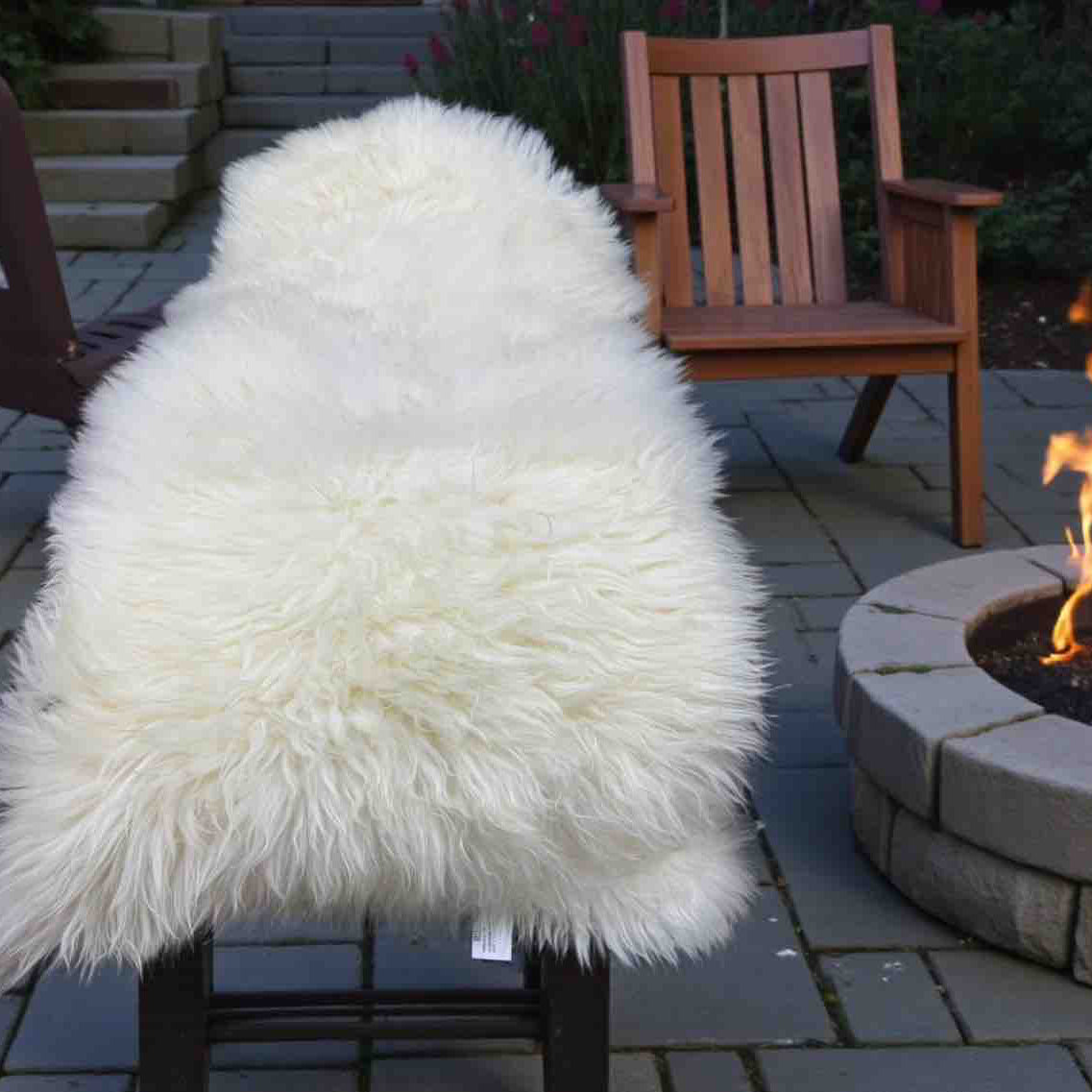 White fluffy chair in front of a fire pit on a patio