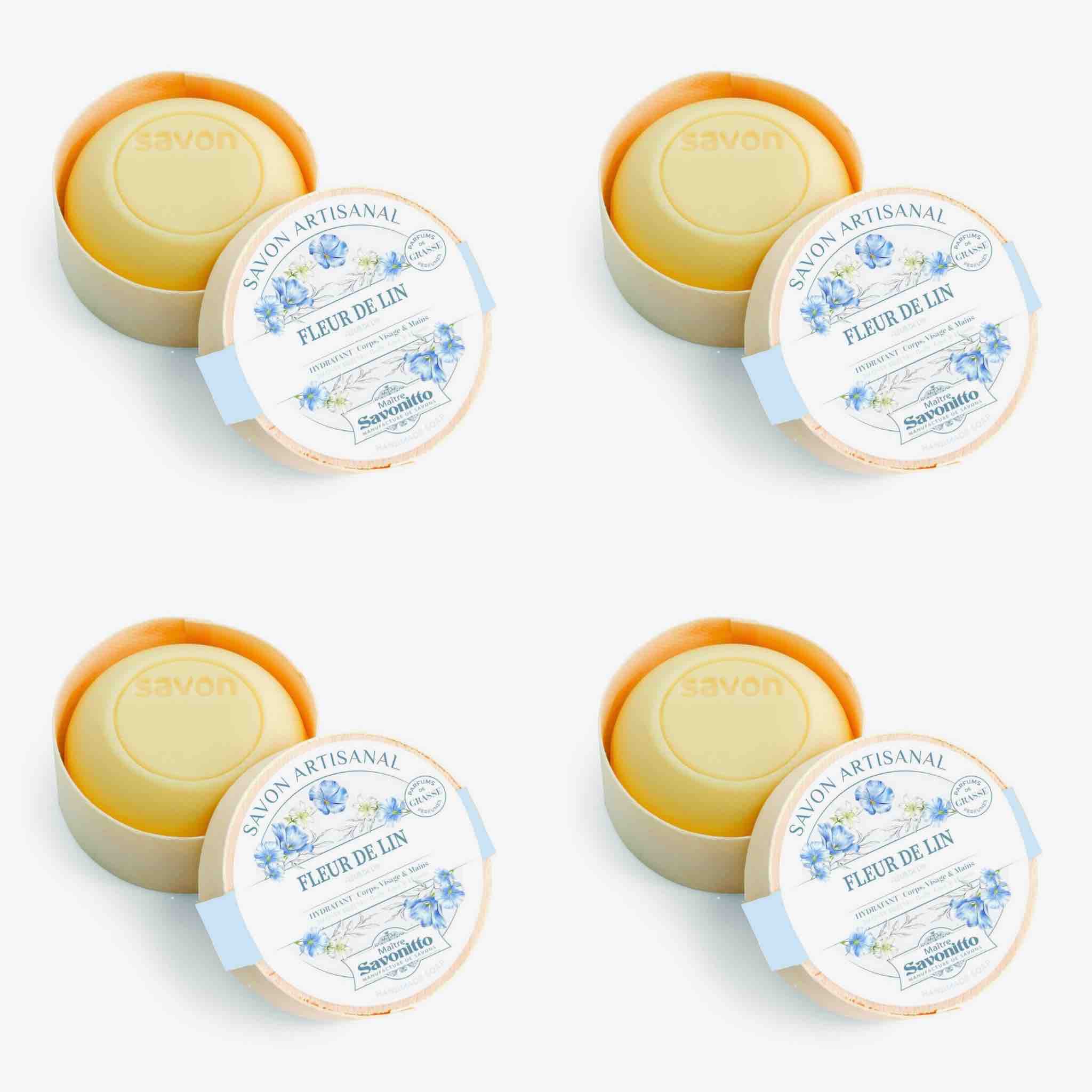 Four round soap bars in their packaging with decorative labels on a white background