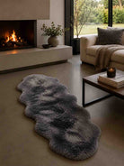 Living room with a gray rug, fireplace, and sofa.