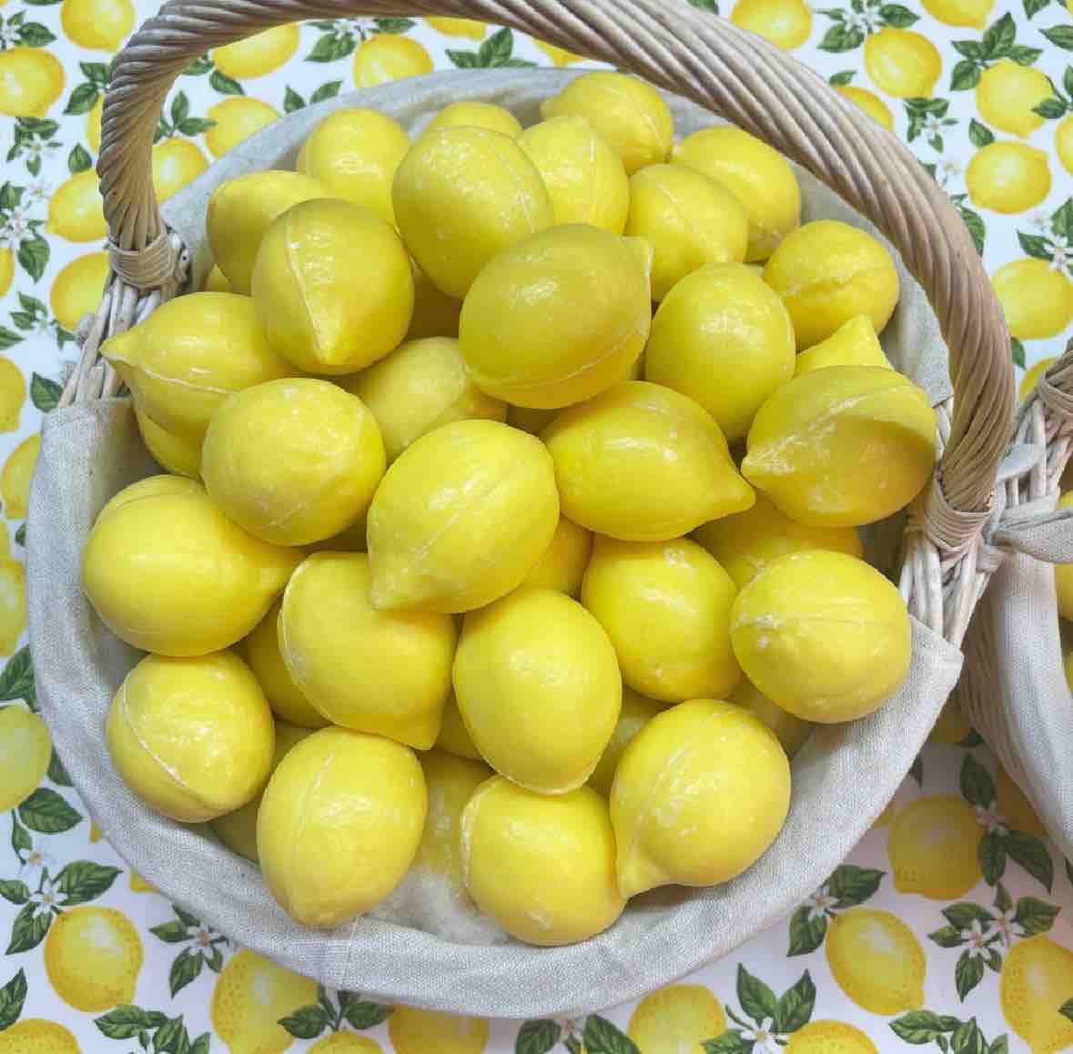 Basket of lemons on a patterned background with lemons and leaves.