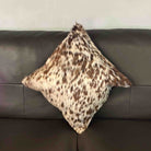 Spotted pillow on a gray sofa against a neutral wall