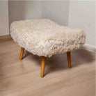Stool with white fluffy cover on a wooden floor
