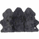 A dark gray shaggy sheepskin rug with a natural irregular hide shape, shown against a plain white background.