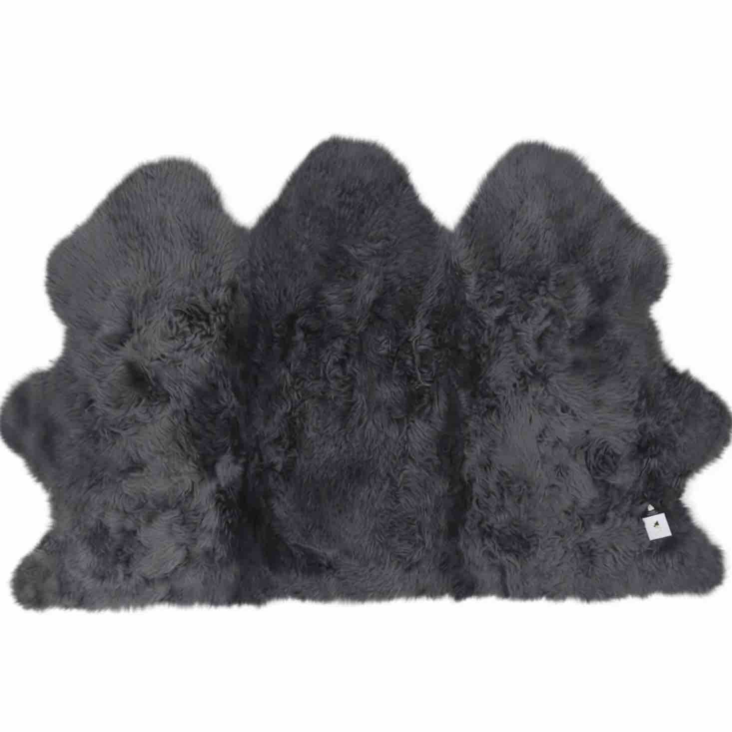 A dark gray shaggy sheepskin rug with a natural irregular hide shape, shown against a plain white background.