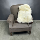 Gray armchair with a white fur throw on a gray floor and background